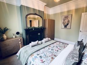a bedroom with a large bed and a mirror at Moody House in Congleton +4 photos