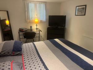 ein Schlafzimmer mit Bett und Flachbildfernseher in der Unterkunft Studio Bx Métropole Eysines A côté du tram in Eysines