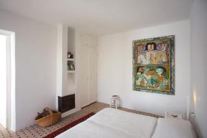 a bedroom with two beds and a painting on the wall at Unique Architect's House in Essaouira