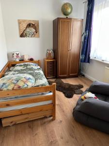 a bedroom with a bed and a couch at Ferienwohnung am Warnowhang in Kessin