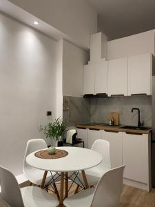 a kitchen with a white table and white chairs at Riara Home in Vlorë