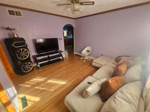 a living room with a couch and a flat screen tv at Dracut Executive Rooms with Kitchen & Bath, Parking, Spacious & Comfortable in Dracut
