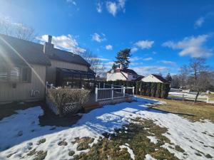 a house with snow on the yard at Dracut Executive Rooms with Kitchen & Bath, Parking, Spacious & Comfortable in Dracut