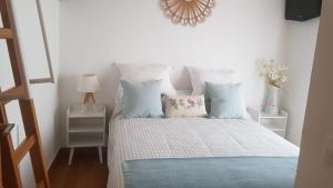 a bedroom with a bed with pillows and a chandelier at CASA VALERO in Cazorla