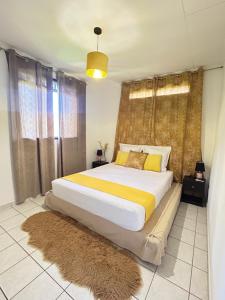 a bedroom with a large bed with yellow and white sheets at Spacieux et lumineux Appartement T3 Cayenne in Cayenne