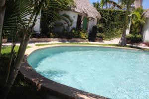 a large swimming pool in front of a house at Hotel Kocai Izamal in Izamal