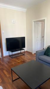 a living room with a couch and a flat screen tv at Marlin City Apartment in Bielefeld