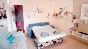 a room with two beds and a blue couch at Panorama e Relax Lago Maggiore - piscina, tennis in Germignaga +30 photos