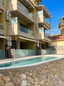 a building with a swimming pool in front of a building at Ariti Luxury Apartment in Nikiana