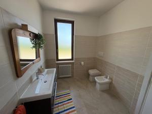 a bathroom with a sink and a toilet and a window at Casa Yoga 2 Rilassati in una oasi di pace immersa nella natura a soli 60 minuti da Roma in Bassano Romano