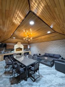 a dining room with a table and a couch at Novxanı Villa in Baku