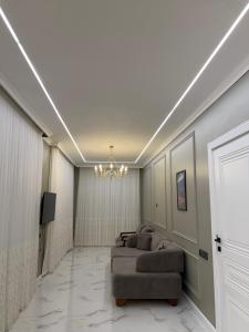 a living room with a couch and a television at Novxanı Villa in Baku