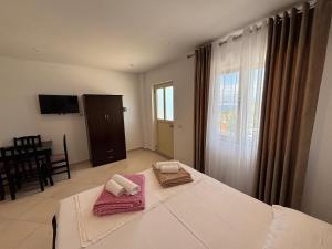 a bedroom with a bed with two towels on it at Grand Seaview Apartments in Ksamil