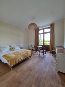a bedroom with a bed and a table and chairs at Domaine de Lasserre in Lupiac