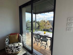 a room with a balcony with a table and chairs at The Nest - cosy chalet for two in Jarjayes