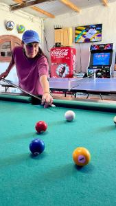 a young woman playing pool on a pool table at Doña Sara in Gualeguay
