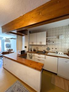 a kitchen with white cabinets and a wooden counter top at Casa Raggio di Sole in La Thuile