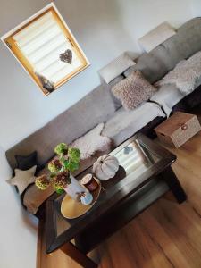 a living room with a couch and a glass table at Romantic cabin in the woods - Fesnga, Slovenia in Slovenj Gradec