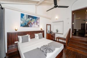 a bedroom with a white bed with a bow on it at Arches Fort in Galle