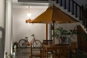 a bike parked next to a table with an umbrella at Arches Fort in Galle