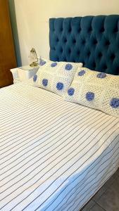 a bed with a blue and white comforter on it at Doña Sara in Gualeguay +33 photos