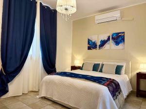 a bedroom with a bed with blue curtains and a chandelier at Blue Dolphin Guest House in Alghero +21 photos