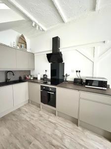 a kitchen with white cabinets and a stove top oven at Cosy Coastal Cottage in Tynemouth +11 photos
