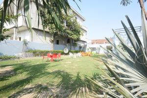a yard with chairs and tables in front of a building at Hotel Stay 21 in Faridabad