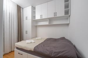 a small bedroom with white cabinets and a bed at Rajjan in Bar