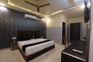 a bedroom with a bed and a ceiling fan at Hotel Stay 21 in Faridabad +14 photos