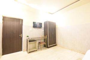 a room with a desk and a tv on a wall at Hotel Stay 21 in Faridabad