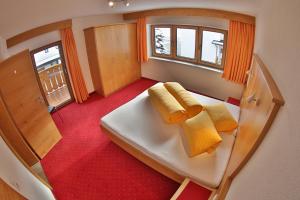 a small room with a bed and two yellow towels at Alpenapart Zell in Längenfeld