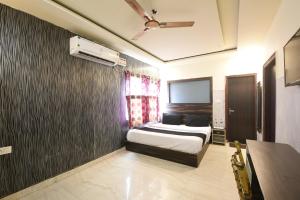 a bedroom with a bed and a ceiling fan at Hotel Stay 21 in Faridabad