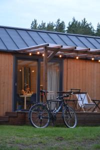 a bike parked in front of a house at Ostoja Wycinki domki letniskowe in Jaszczerz