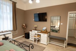 a bedroom with a desk and a mirror at Kispolgár Vendégház in Sárospatak
