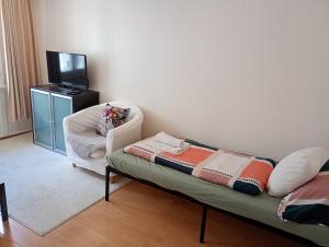 a living room with a couch and a chair at Central tiny studio in St. Gallen
