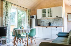 a kitchen with a table and chairs in a room at Ostoja Wycinki domki letniskowe in Jaszczerz +31 photos