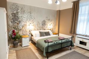 a bedroom with a bed with a floral wallpaper at Kispolgár Vendégház in Sárospatak