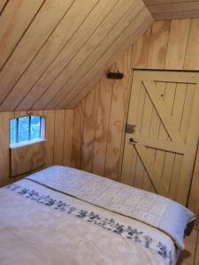 a bedroom with a white bed with a door at Woonwagen Carpe Diem in Oudwoude