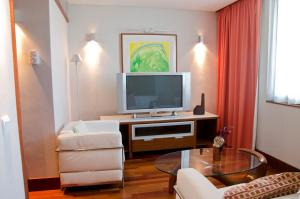 a living room with a television and a table at VIP Executive Arts Hotel in Lisbon