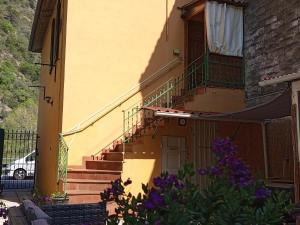 a building with stairs and a balcony with purple flowers at La Yucca in Dolceacqua
