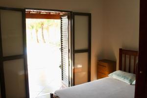 a bedroom with a bed and a sliding glass door at Chacara Mariana in Olímpia +26 photos