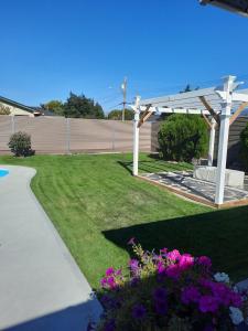 a garden with a white pergola and purple flowers at Endless Summer in Summerland