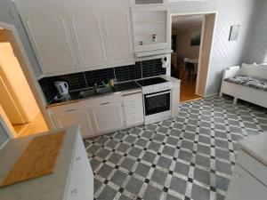 a kitchen with white cabinets and a checkered floor at Familjenest in Bollnäs +18 photos