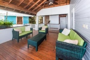 a porch with chairs and couches on a deck at Top Ridge Views home in Roatán