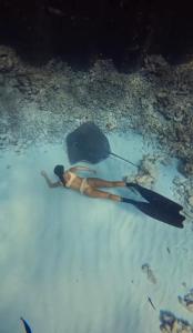 a woman swimming in the water in the ocean at Amazonite Maldives in Thulusdhoo +10 photos