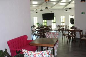 a room with tables and chairs and a flat screen tv at Hotel Kocai Izamal in Izamal
