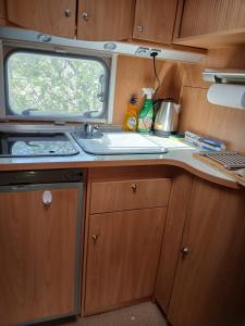 a kitchen in an rv with a sink and a window at La Ventana - Jardin & Parking in Étretat