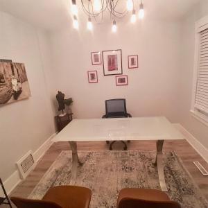 a dining room with a white table and chairs at Black door bungalow in Windsor +2 photos