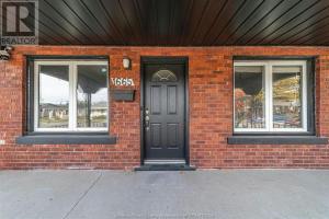 a brick building with a black door and two windows at Black door bungalow in Windsor